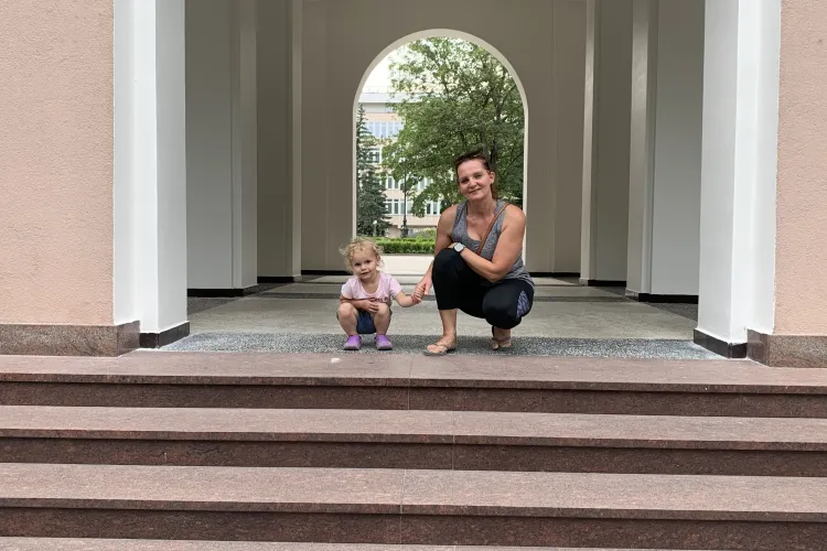 Dr Joanna Piasecka-Srader kuca z córką przed wejściem do rektoratu