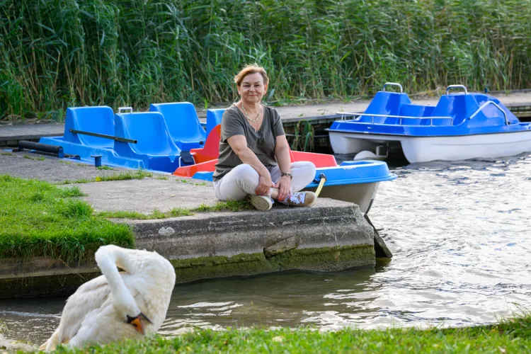Grażyna Furgała-Selezniow siedzi na przystani kortowskiej nad jeziorem
