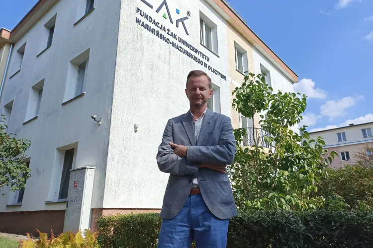 Tomasz Wierzejski stoi na tle budynku Fundacji "Żak"