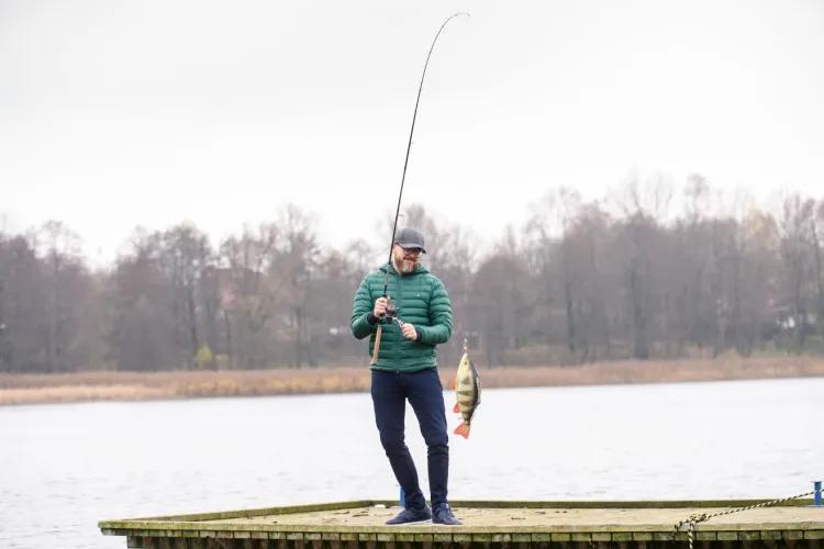 Krzysztof Kupren na pomoście z wędką