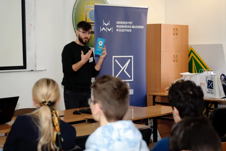 student stoi przed tablicą i coś mówi