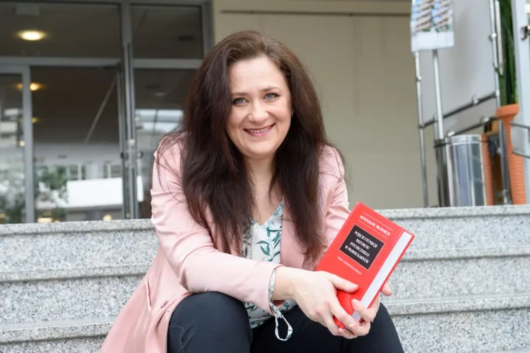 dr hab. Marta Romańczuk-Grącka, siedzi z książką w ręku