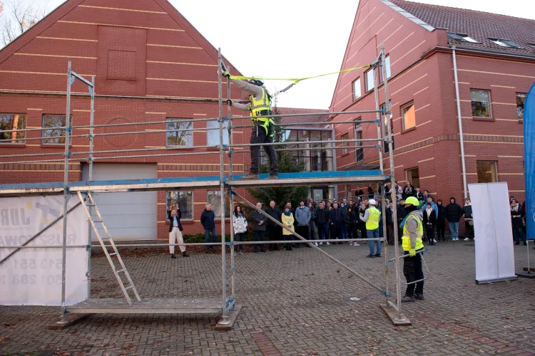 ludzie przygladają się montażowi rusztowania