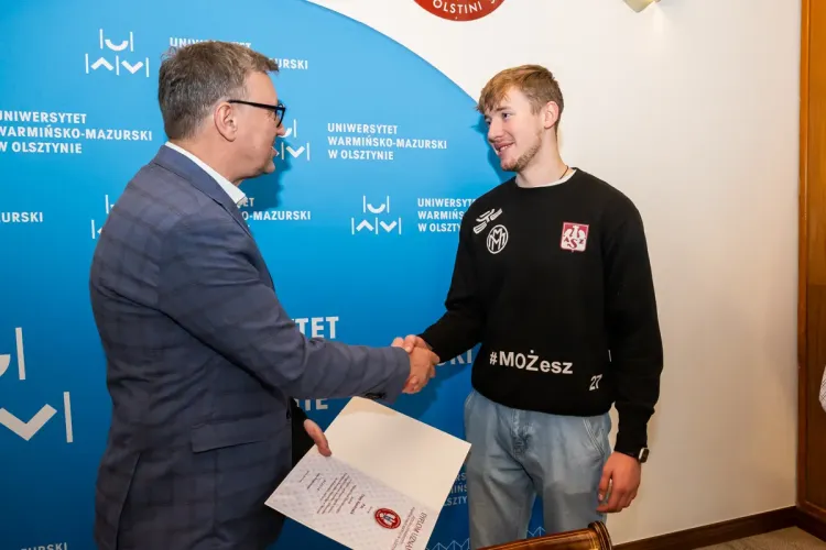 Rektor wręcza nagrodę zawodnikowi AZS UWM Olsztyn