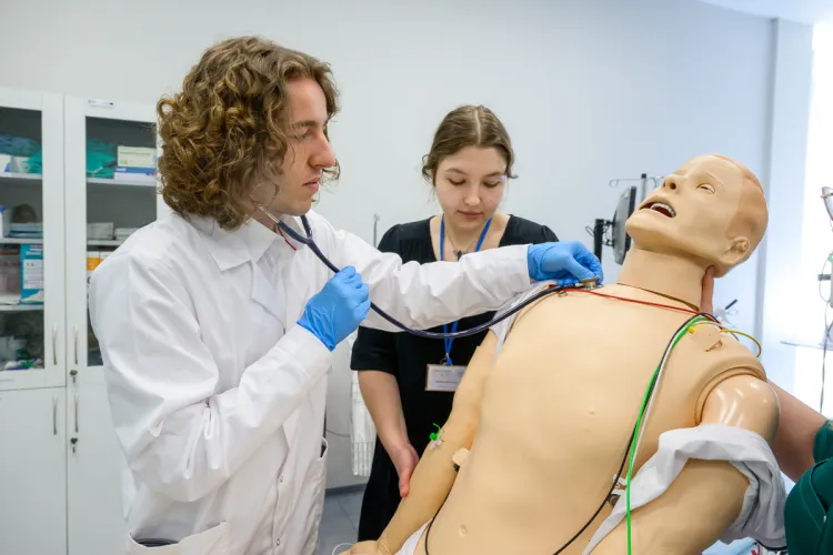student w fartuchu lekarskim bada fantoma pacjenta
