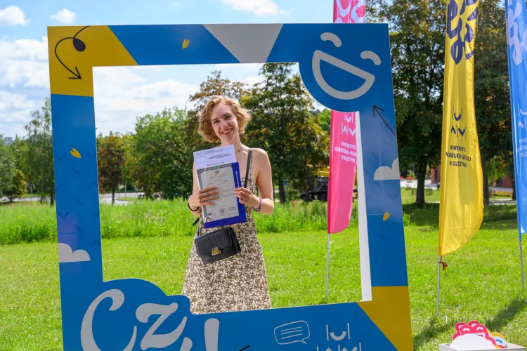 Strefa Kandydata przed Biblioteką Uniwersytecką UWM - nowa studentka UWM pozuje do zdjęcia