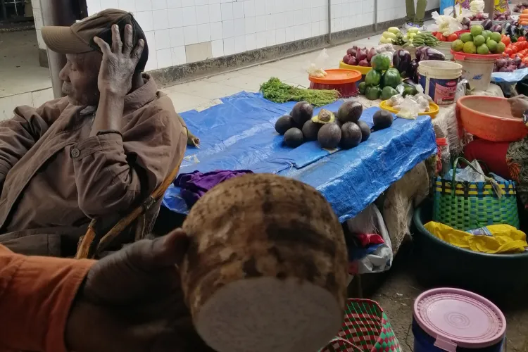 Korzeń manioku, w tle targ na Zanzibarze