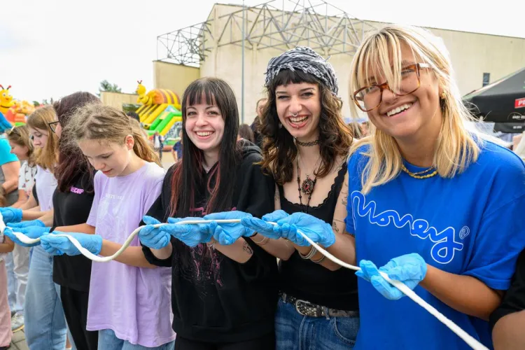 Święto Sera w Olsztynie. Na zdjęciu znajduje się kilka uśmiechniętych dziewczyn trzymających rozciągnięty ser mozzarella