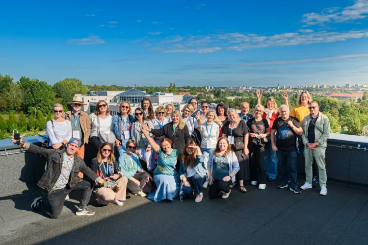 XXXII Konferencja Redaktorów Czasopism Akademickich i Portali Uczelnianych w Olsztynie - zdjęcie grupowe uczestników na dachu Kortosfery, w tle panorama Olsztyna
