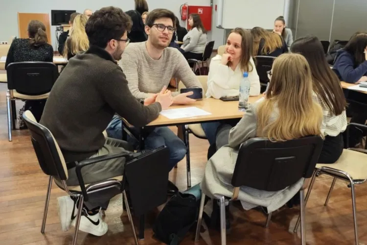 studenci siedzą i omawiają plan biznesowy przedsiębiorstwa społecznego