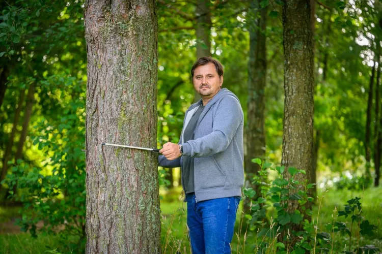 Sławomir Piętka stoi przy drzewie