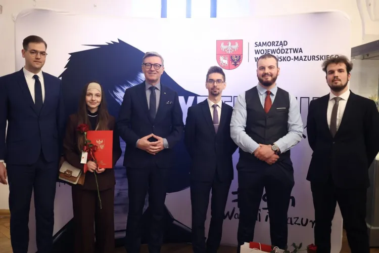 Kilkoro stypendystów pozuje do zdjęcia z rektorem UWM