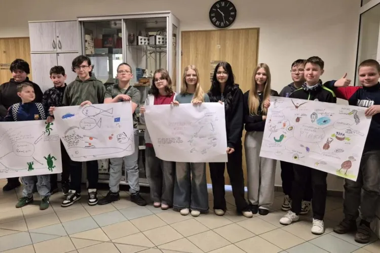 młodzież stoi z kartkami