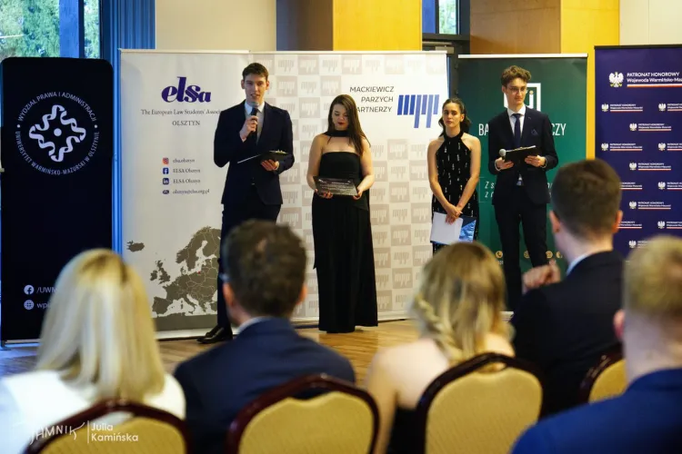 Cztery osoby stoją przed publicznością podczas gali 25-lecia ELSA Olsztyn