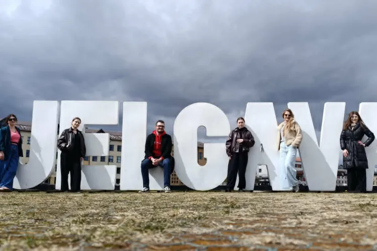 Uczestnicy BIP stoją przy dużym napisie Jelgawa 