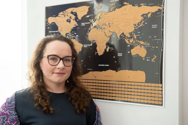 Dr Dominika Kuberska przy mapie świata