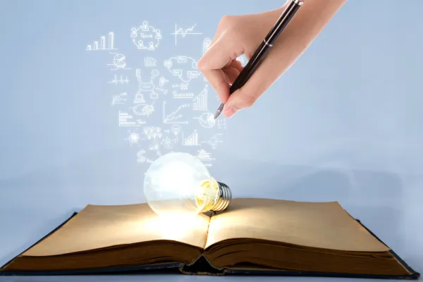 Zdjęcie ilustracyjne (żarówka leżąca na książce) - fot. jannoon028/Freepik.com