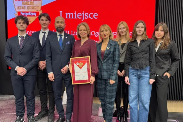 Dyrekcja i uczniowie Uniwersyteckiego XII LO pozują wspólnie z prof. Sławomirem Przybylińskim, prorektorem UWM do zdjęcia. Dyrektorka szkoły Dorota Linkiewicz trzyma w ręku dyplom