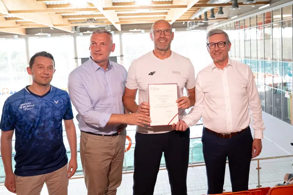 od prawej: prof. Jerzy Przyborowski - rektor UWM, Jakub Rutnicki - minister sportu i turystyki, Paweł Papke, poseł oraz przedstawiciel Samorządu Województwa Warmińsko-Mazurskiego pozują na tle pływalni uniwersyteckiej