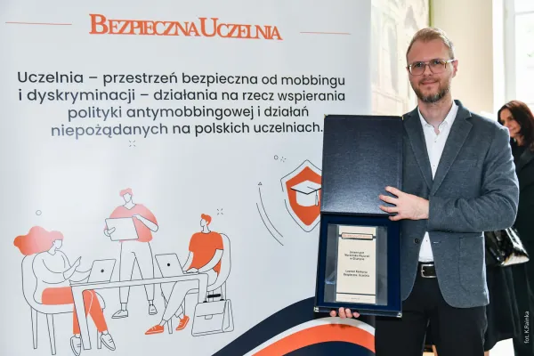 Rzecznik ds. równości szans pozuje z nagrodą Bezpieczna Uczelnia dla UWM
