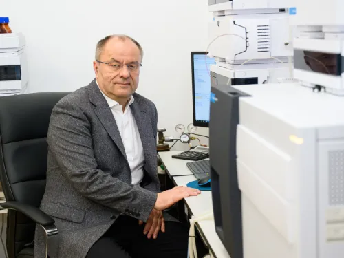 Prof. Łukasz Zielonka siedzi przy biurku