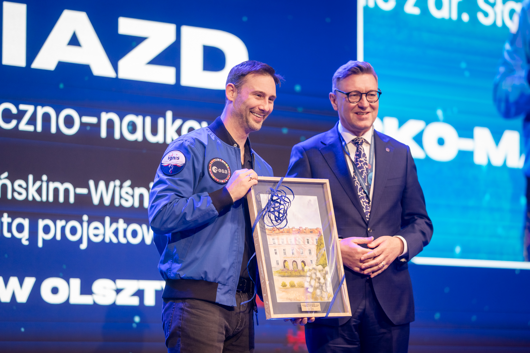 dr Sławosz Uznański-Wiśniewski pozuje do zdjęcia z rektorem UWM